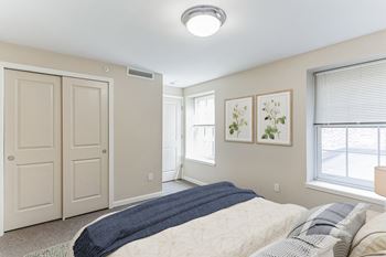 A bedroom with a bed and two windows